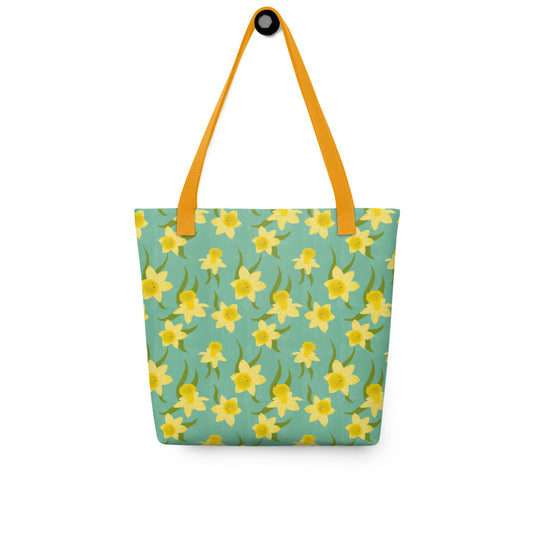 Tote bag with yellow Daffodil floral pattern on a teal background by Carmel Rimmer. Item is photographed on a white background.